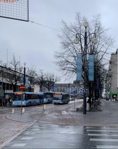 Lahden sateista kaupunkimaisemaa, jossa on muutama bussi ja katupuita.