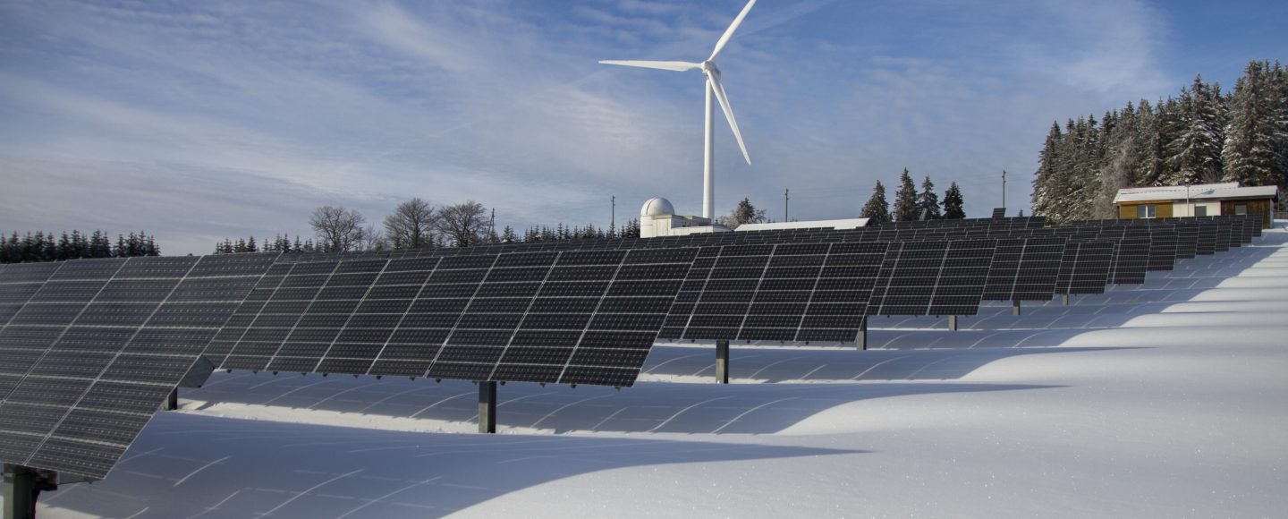 A landscape with solar panels and a windmill