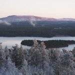 Lapin erämaiden hiljaisuus on aistittavissa tässä seesteisessä kuvassa, jossa näkyy tunturi, tyyni järvi ja metsää.