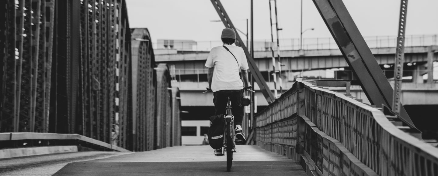 Riding a bike on a bridge in a city